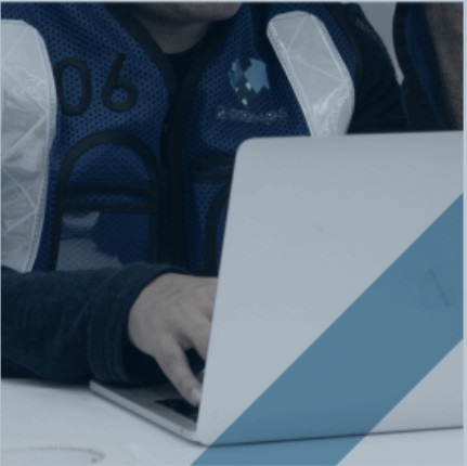 Integrante del equipo Chronos trabajando en una laptop en el almacén