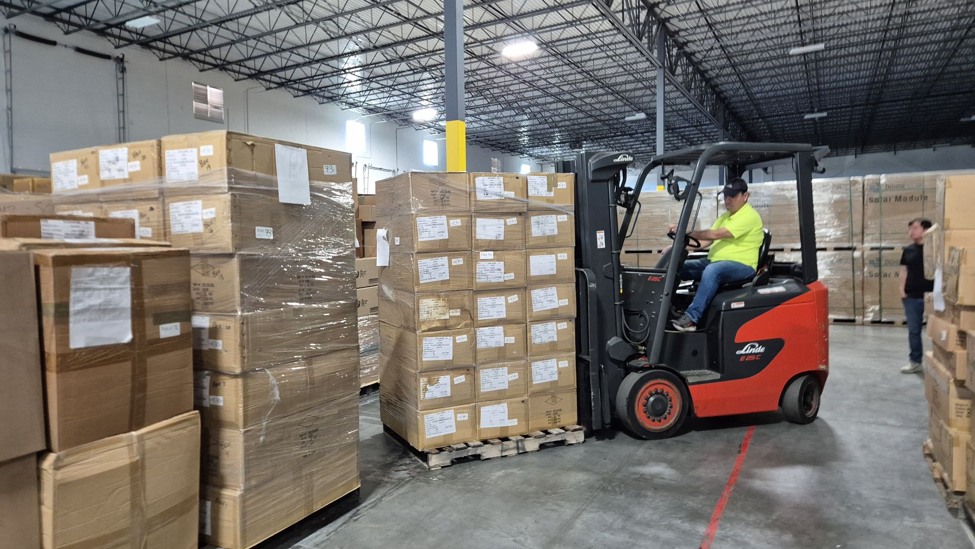 Operador de montacargas moviendo inventario en tarimas dentro del almacén de Chronos USA en Houston, TX
